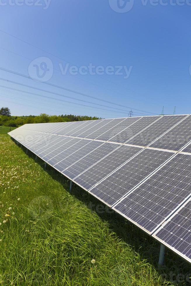 zonnecentrale op de zomerbloeiende weide foto