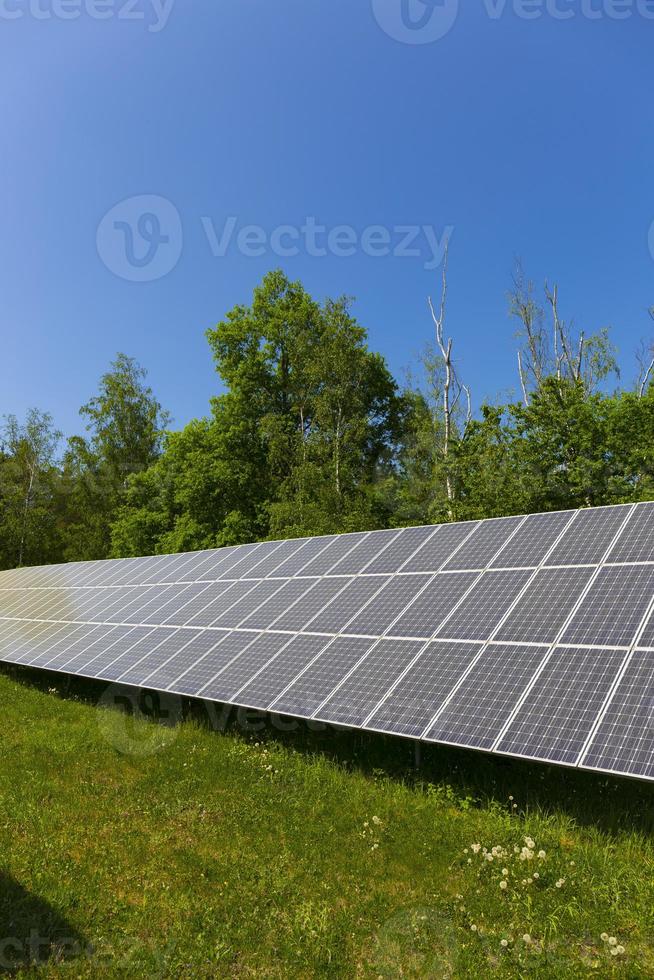 zonnecentrale op de zomerbloeiende weide foto