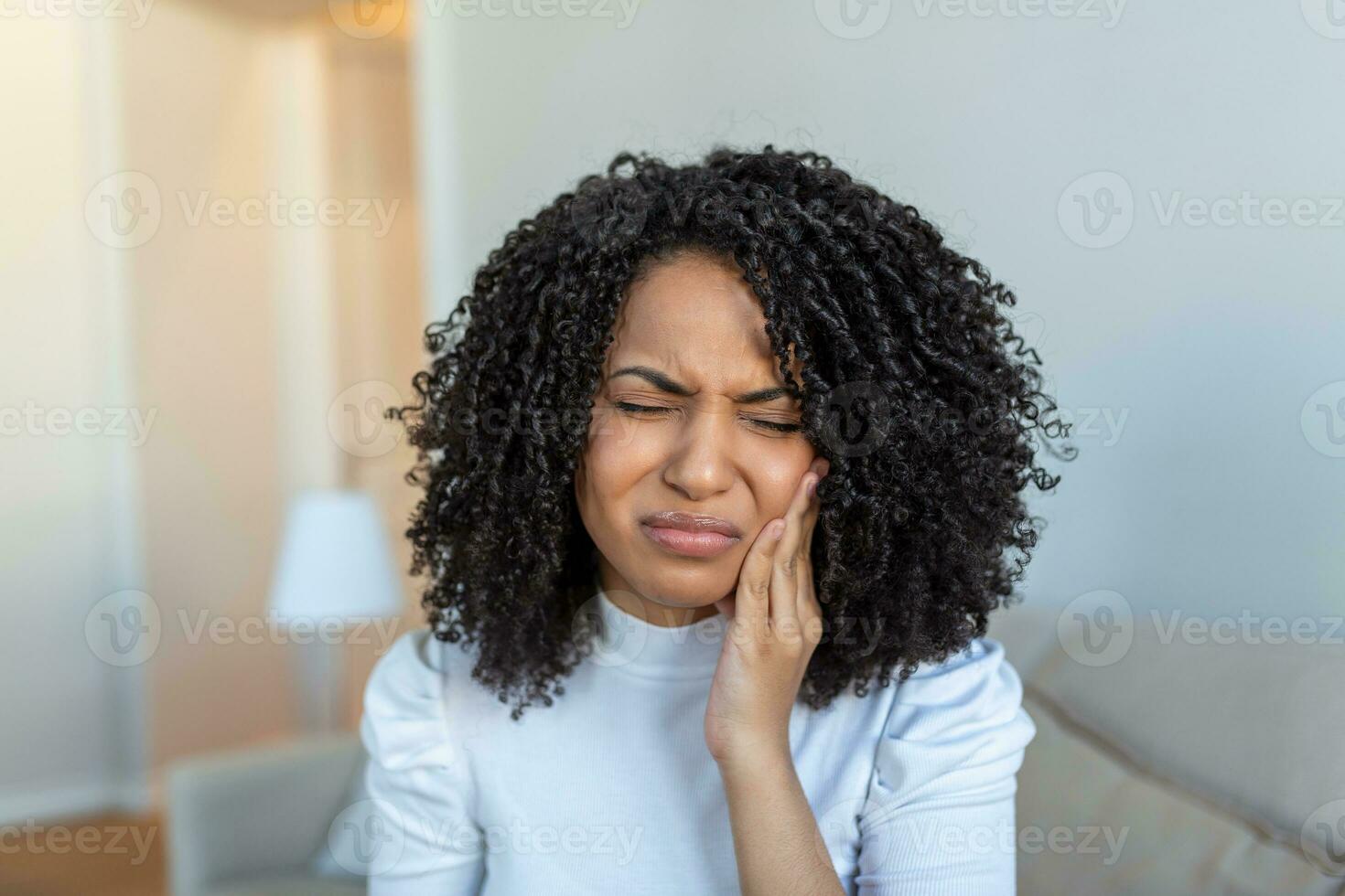 tand pijn en tandheelkunde. mooi jong vrouw lijden van vreselijk sterk tanden pijn, aanraken wang met hand. vrouw gevoel pijnlijk kiespijn. tandheelkundig zorg en Gezondheid concept. hoog resolutie foto