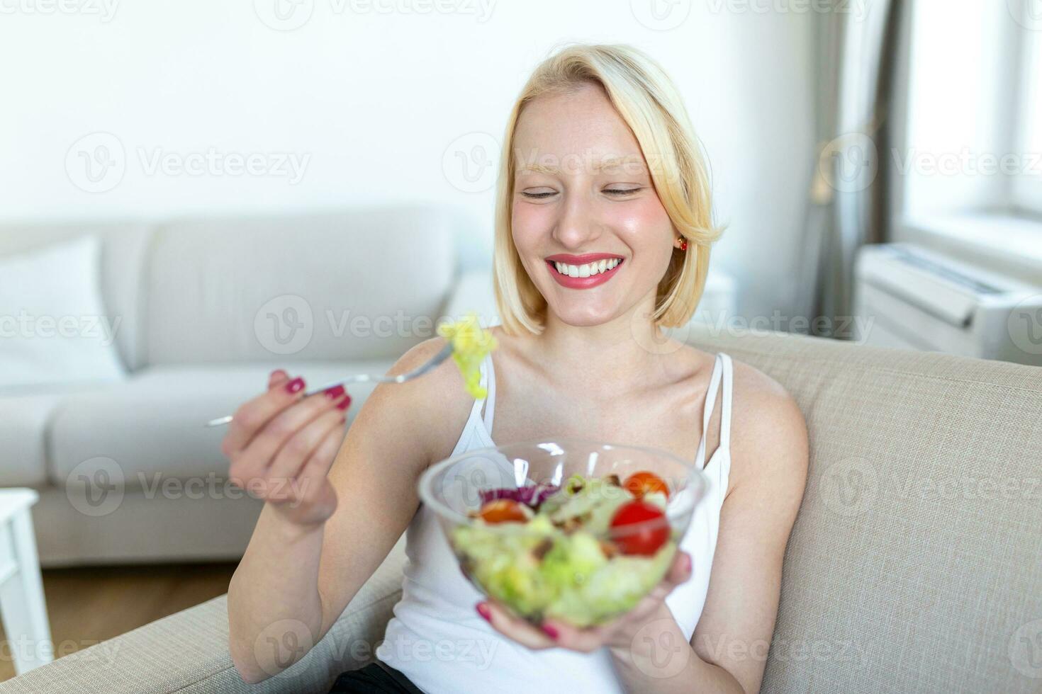 jong fit vrouw aan het eten gezond salade na training. geschiktheid en gezond levensstijl concept. gezond jong vrouw aan het eten groen salade foto