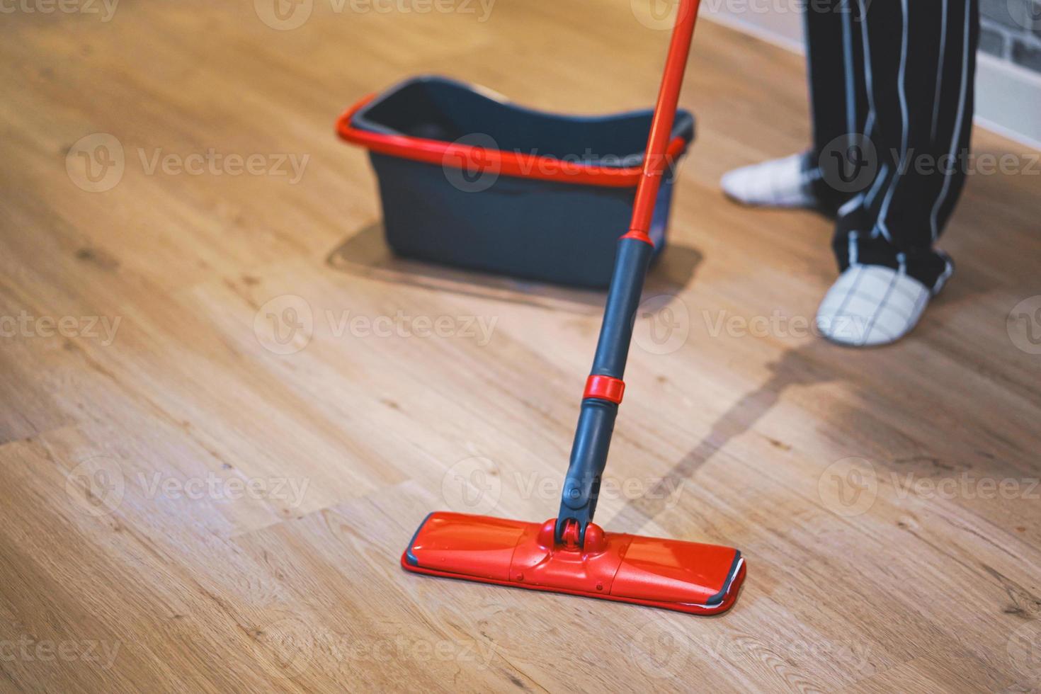 vrouw die de vloer van de woonkamer schoonmaakt door menigte. foto