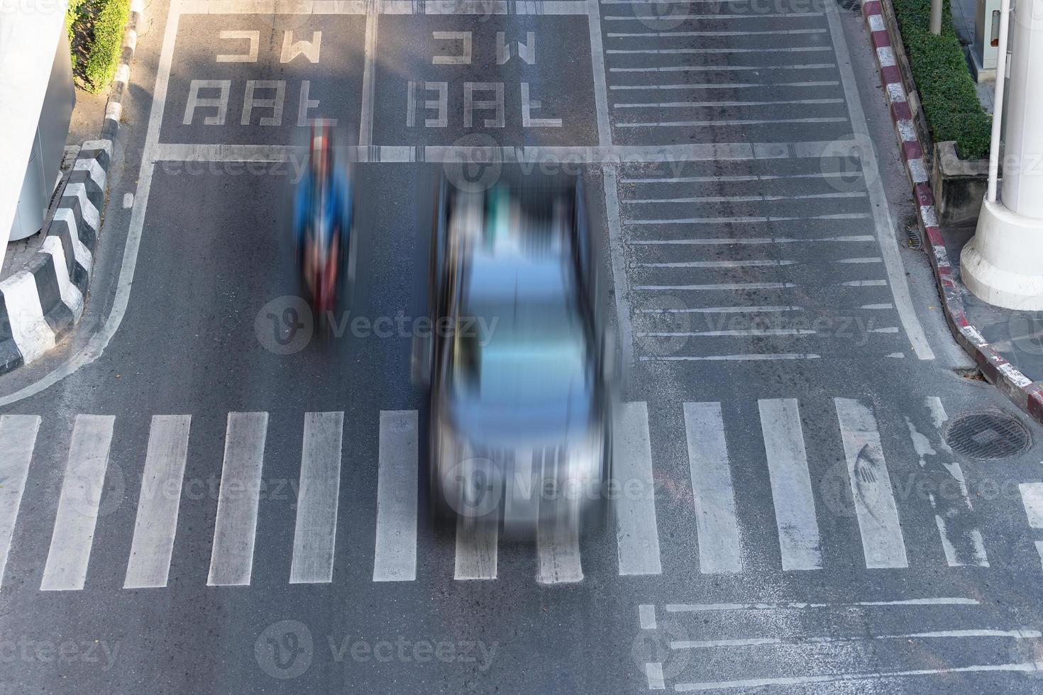 zebrapad en auto, drukke stadsstraat en auto in bewegingsonscherpte op zebrapad foto