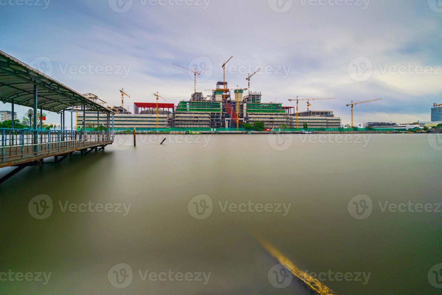 bouwconstructieplaats en kranen naast de rivier, lange blootstelling foto