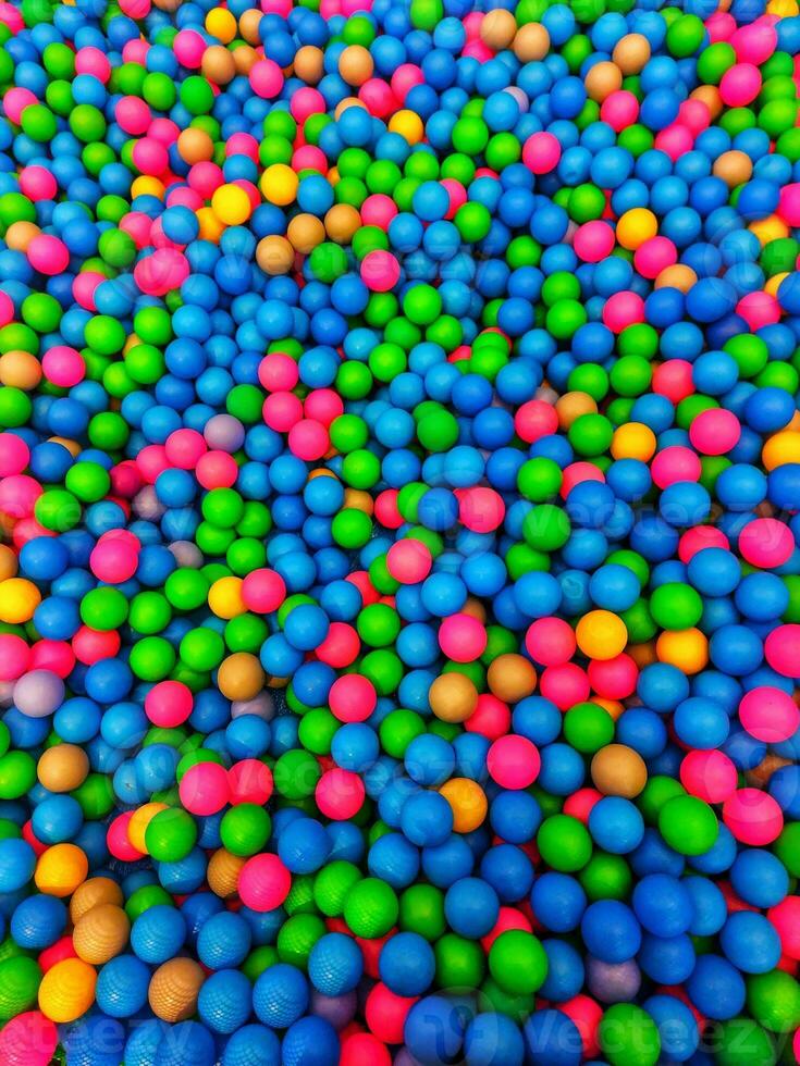 gekleurde plastic ballen zijn verspreide. veel van veelkleurig pret ballonnen.veel kleurrijk plastic ballen in een kinderen' ballenbak Bij een speelplaats. dichtbij omhoog patroon foto