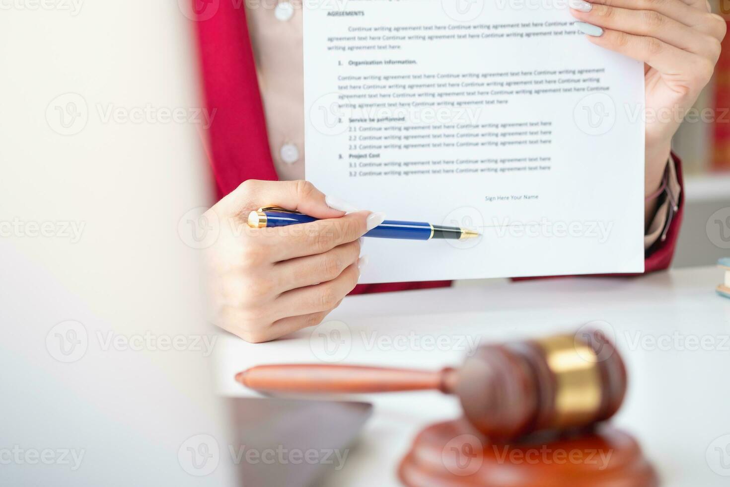 Aziatisch vrouw advocaat of wettelijk adviseur ondertekening een contract de contract documenten dat werk Aan uw bureau in de wet kantoor zijn Daar naar gids jij. foto