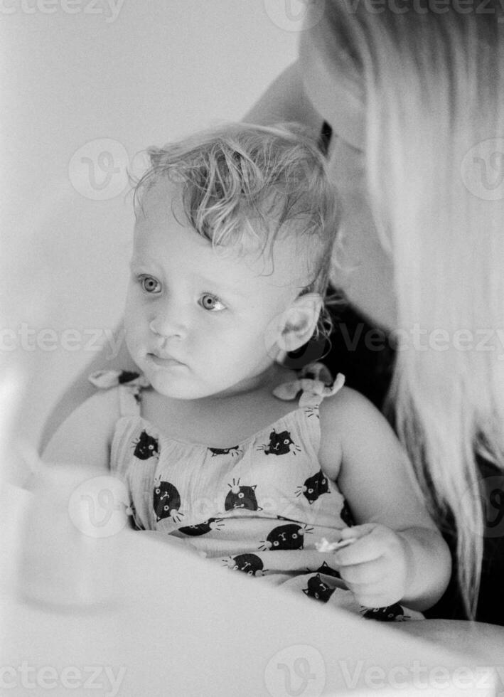 zwart en wit portret van baby meisje met mamma Bij huis foto