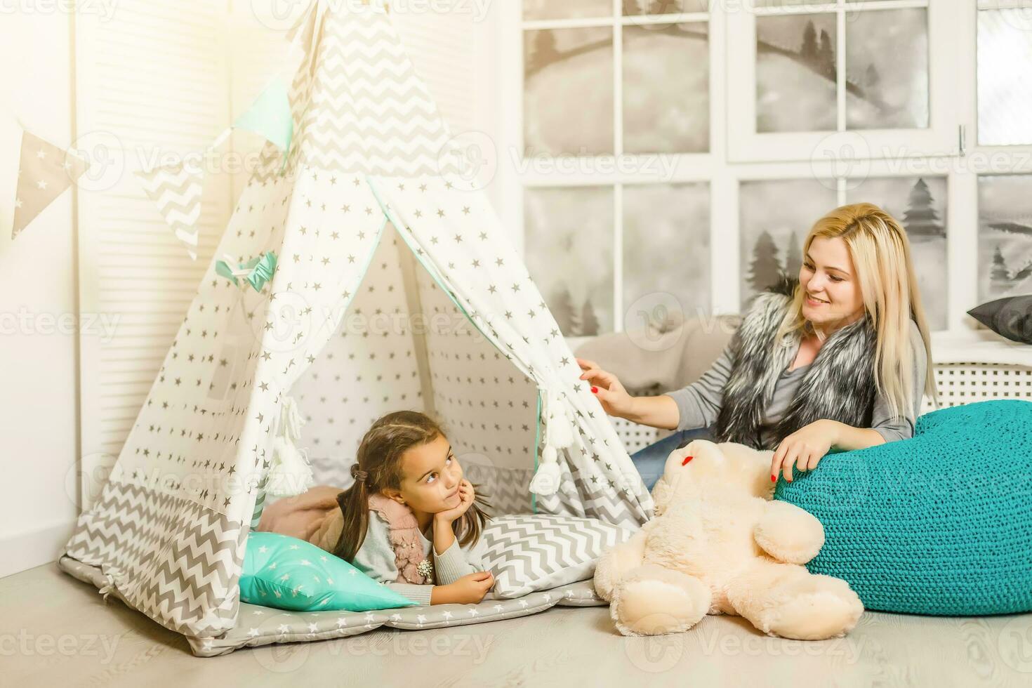 gelukkig familie moeder en dochter kind meisje spelen met speelgoed- teddy beer huis foto
