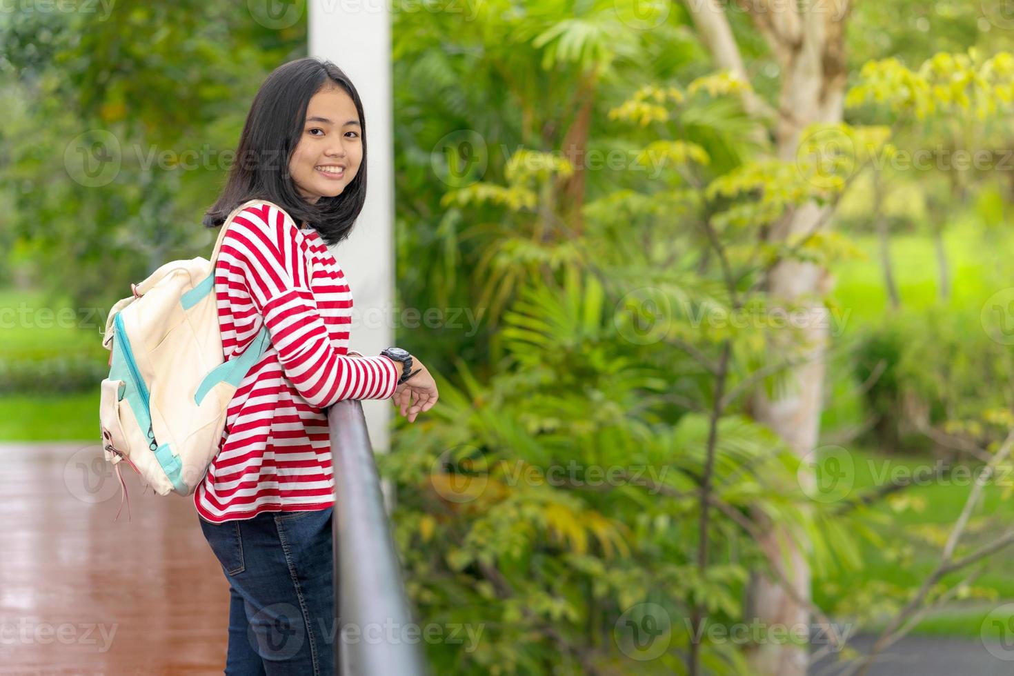 Aziatisch studentenmeisje dat op een zonnige zomerdag in het schoolpark staat foto