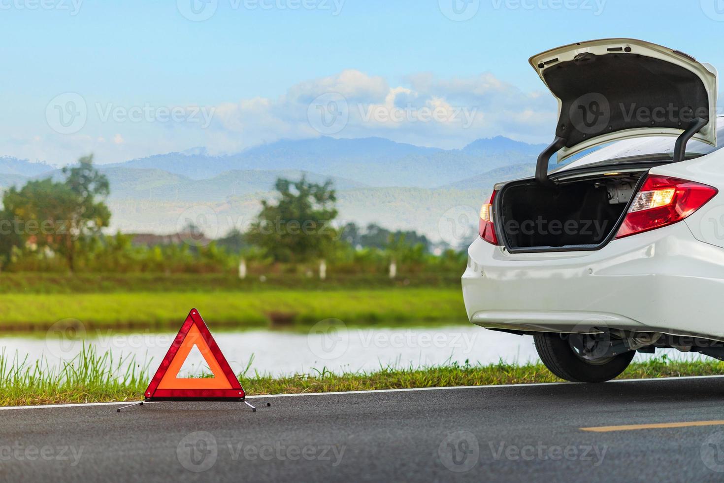 problemen auto en een rode driehoek waarschuwingsbord op de weg foto