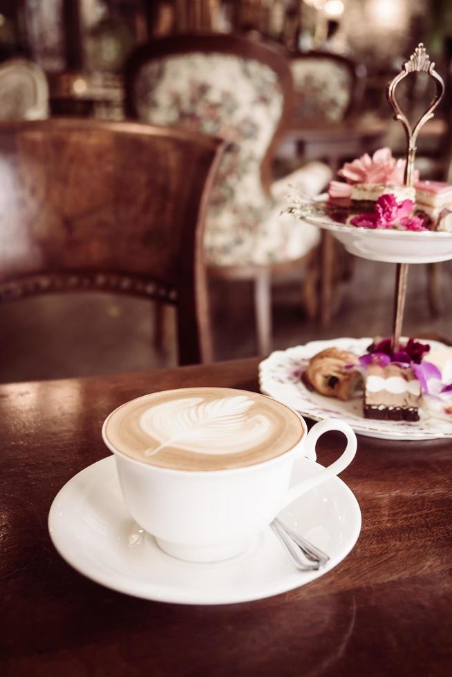 witte kop met latte koffie en cake foto