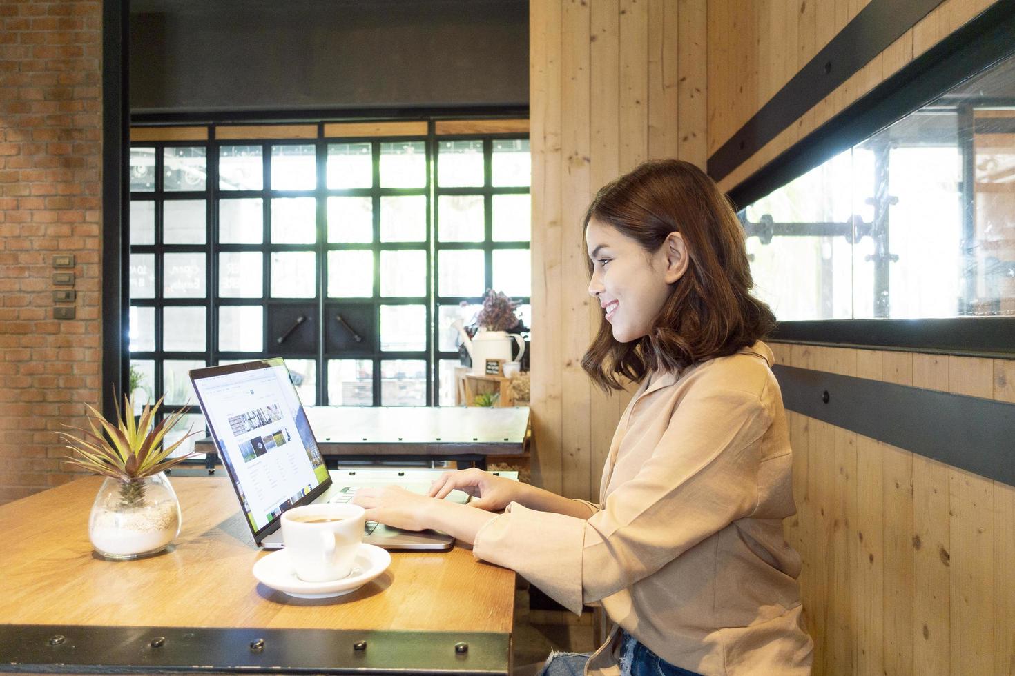 mooie zakenvrouw werkt met haar laptop in coffeeshop foto