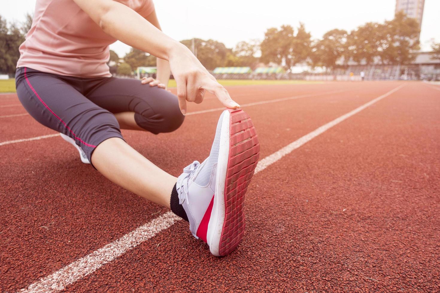 close-up sportieve vrouw is stretch in sportveld foto