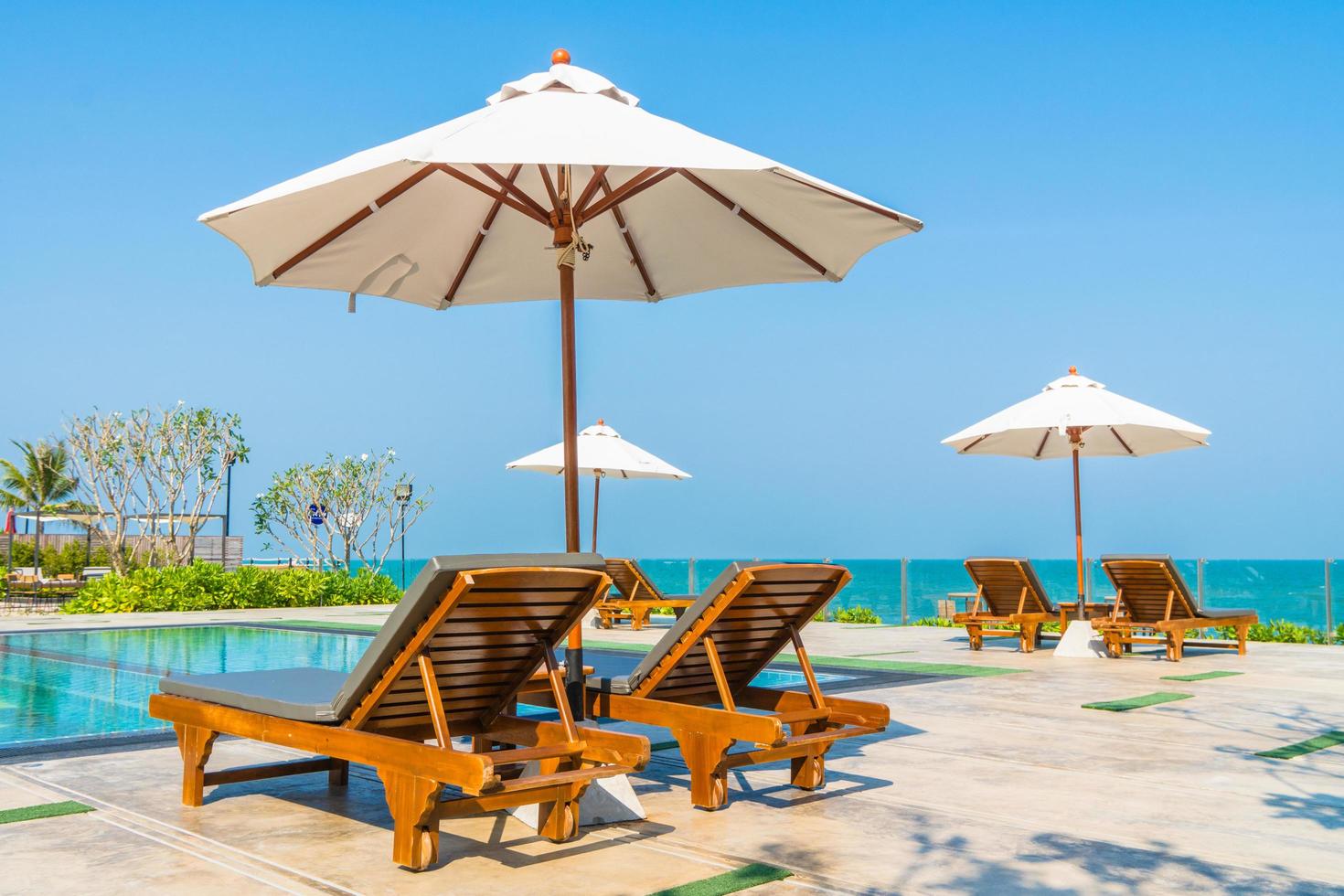 mooie parasol en stoel rond zwembad in hotel en resort foto