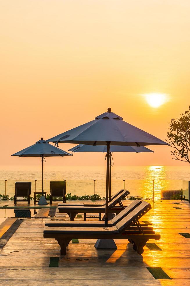 mooie parasol en stoel rond zwembad in hotel en resort foto