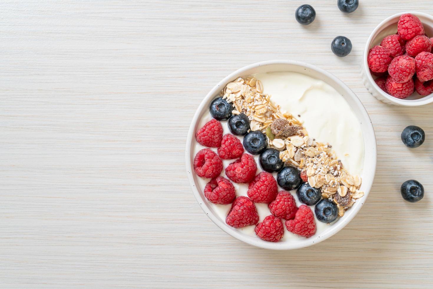 zelfgemaakte yoghurtkom met framboos, bosbes en granola - gezonde voedingsstijl foto