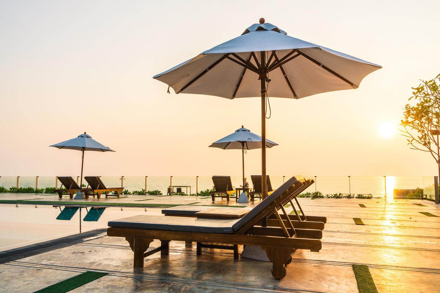 mooie parasol en stoel rond zwembad in hotel en resort foto