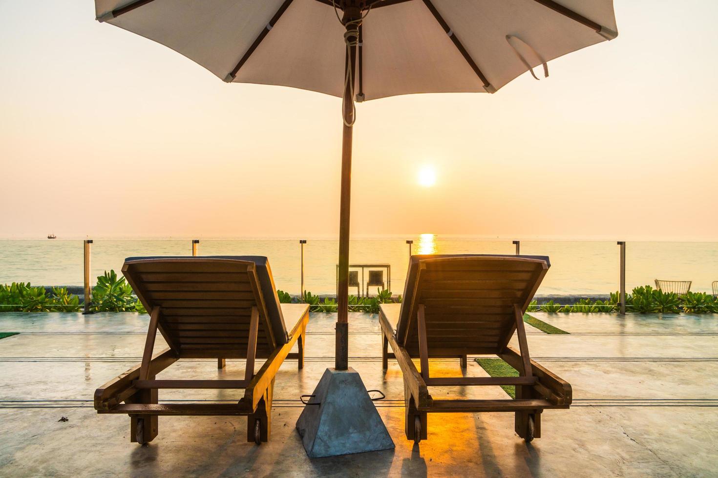 mooie parasol en stoel rond zwembad in hotel en resort foto