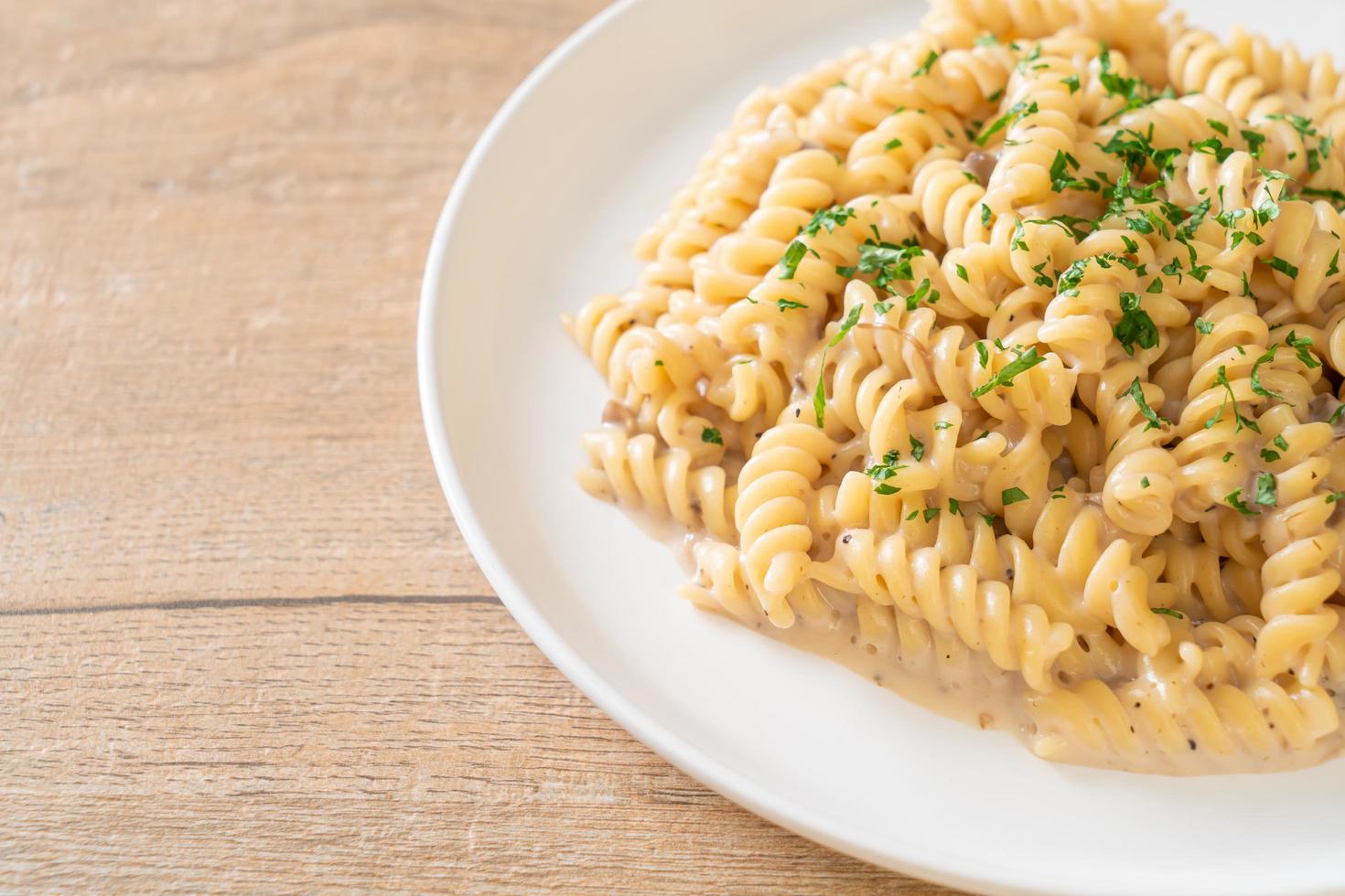 spirali of spirali pasta champignonroomsaus met peterselie - italiaanse eetstijl foto