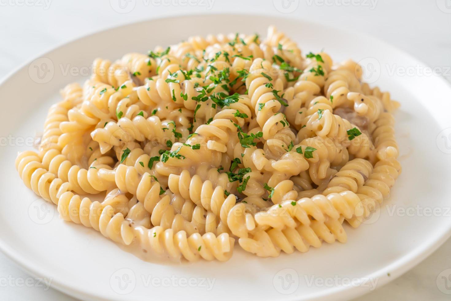 spirali of spirali pasta champignonroomsaus met peterselie - italiaanse eetstijl foto