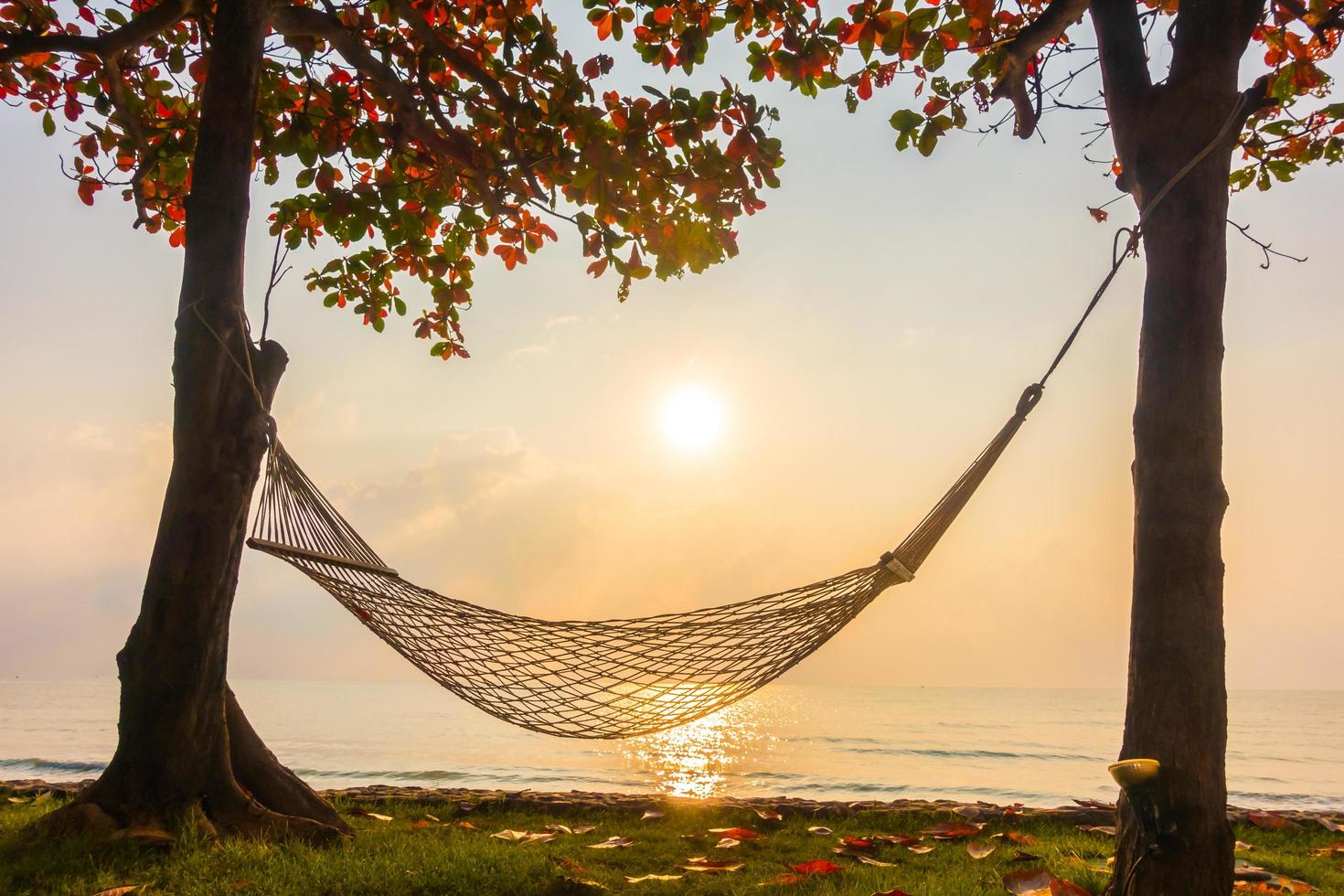 hangmat in de buurt van strand en zee bij zonsopgang foto