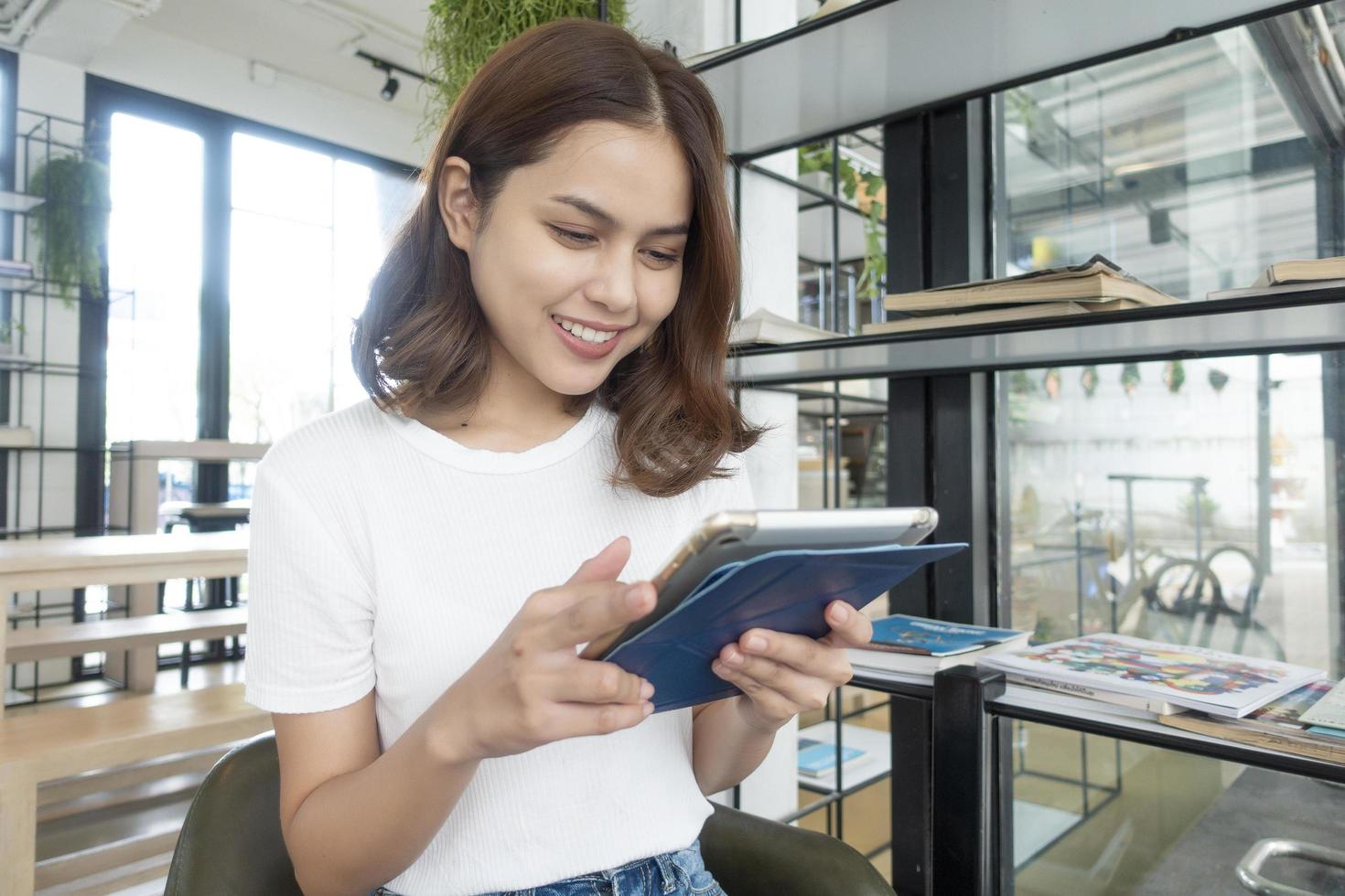 mooi zakelijk meisje dat werkt met tablet, smartphone en koffie drinkt in de coffeeshop foto