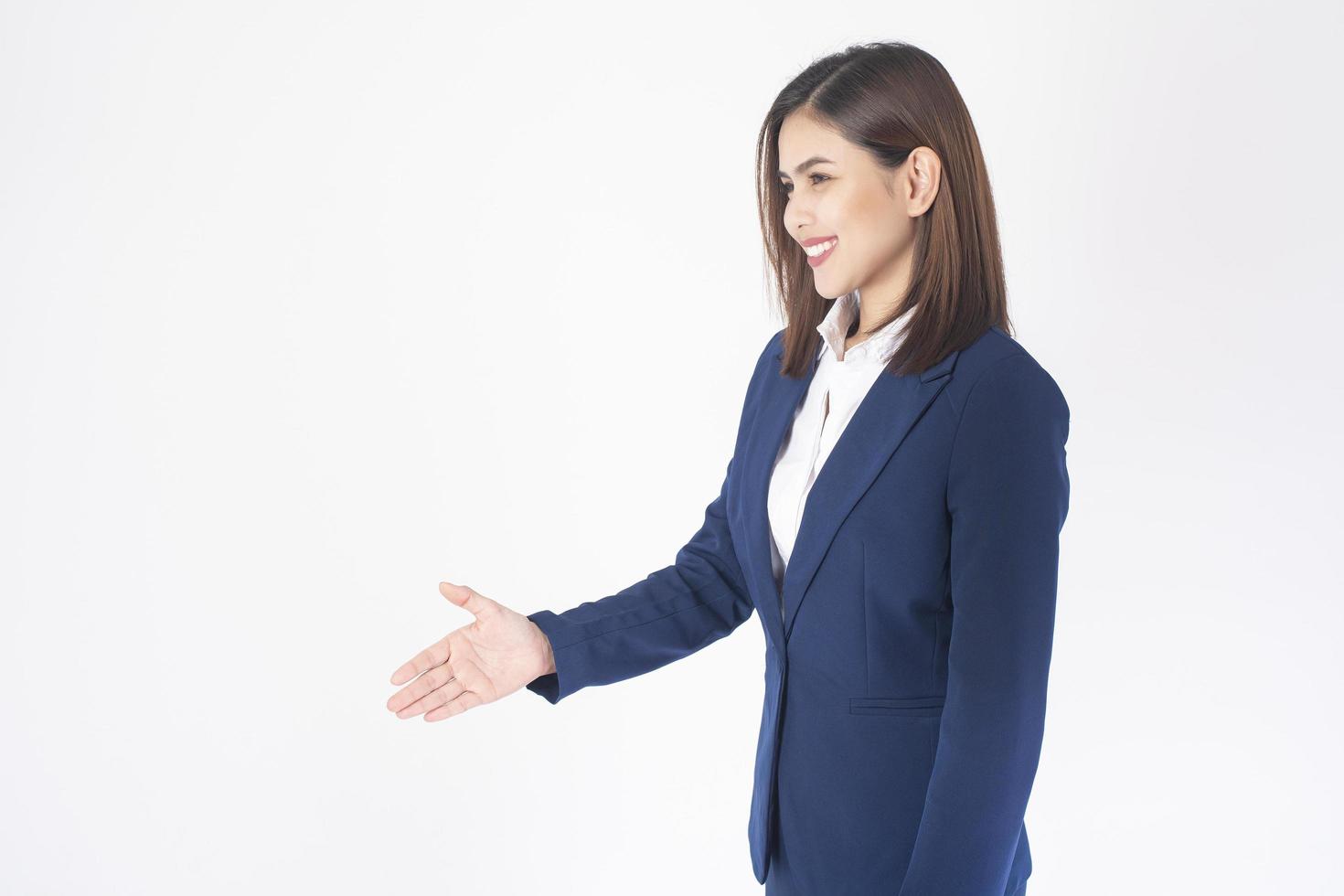 vrouw in blauw pak schudt de hand op een witte achtergrond foto