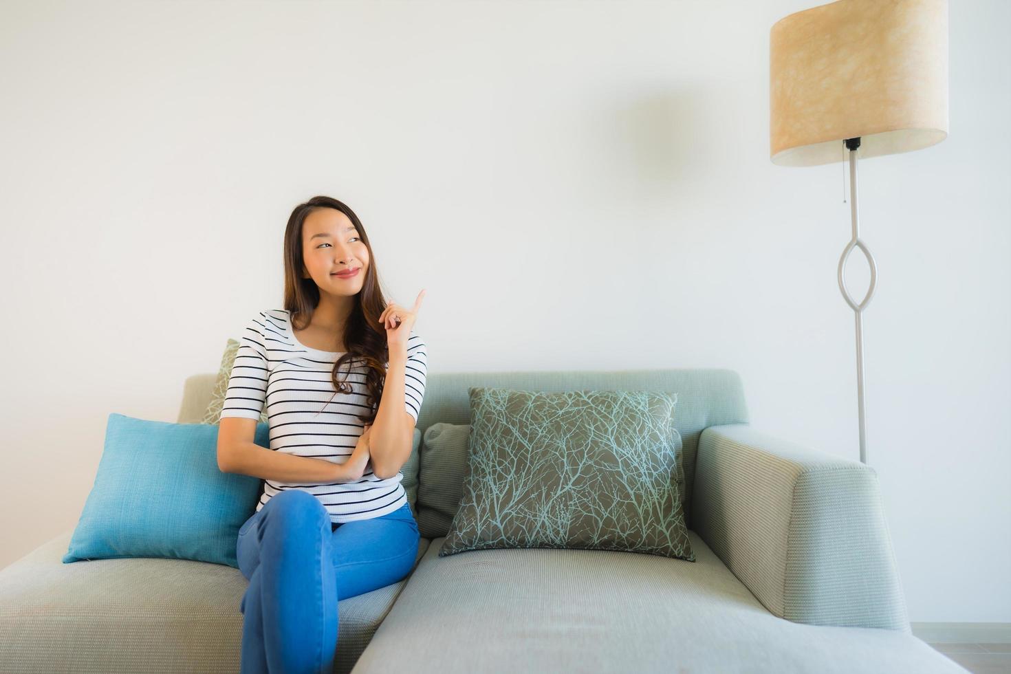 portret mooie jonge aziatische vrouw glimlach gelukkig op de bank foto