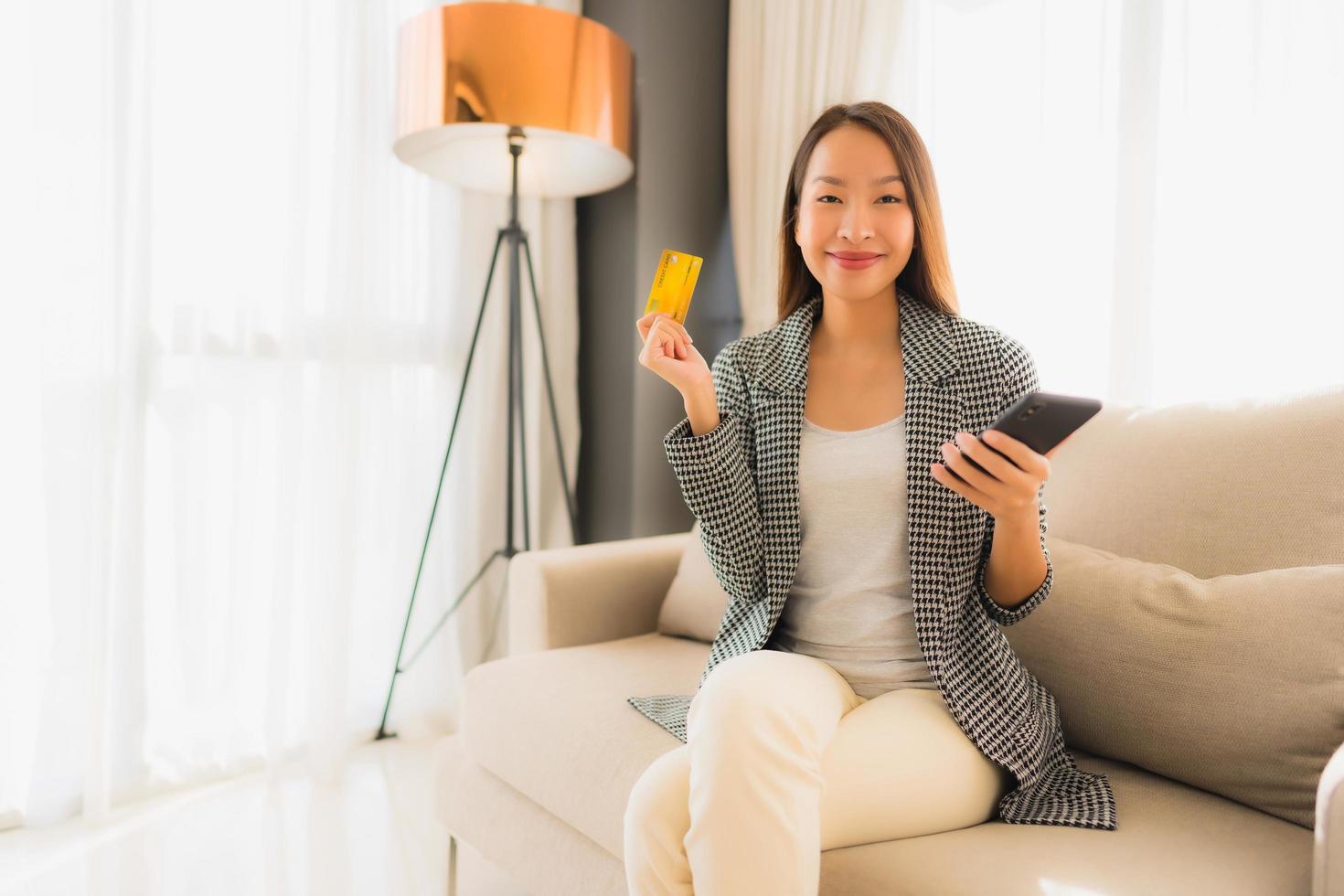 portret mooie jonge aziatische vrouwen die computerlaptop of slimme en mobiele telefoon met creditcard gebruiken voor online winkelen foto