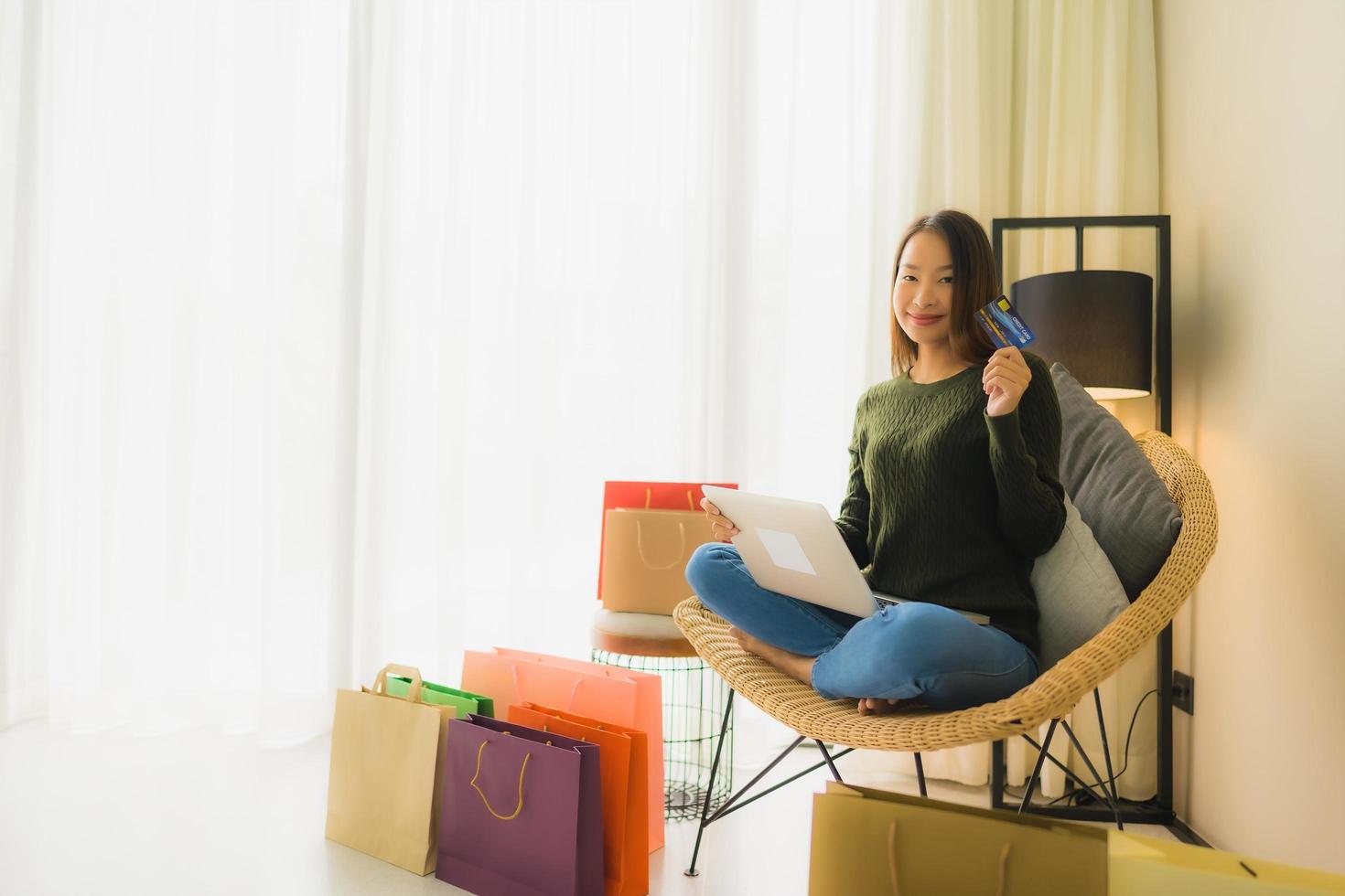 portret mooie jonge aziatische vrouwen die computerlaptop of slimme en mobiele telefoon met creditcard gebruiken voor online winkelen foto