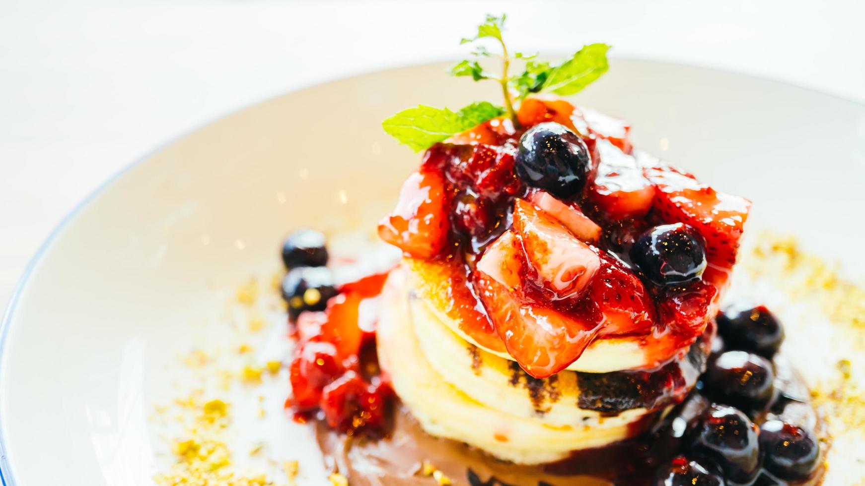 pannenkoeken met gemengd bessenfruit in witte plaat foto