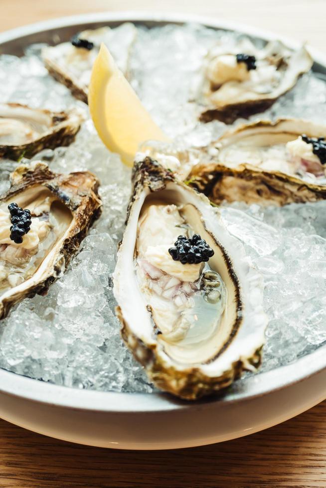 rauwe en verse oester met kaviaar erop en citroen foto