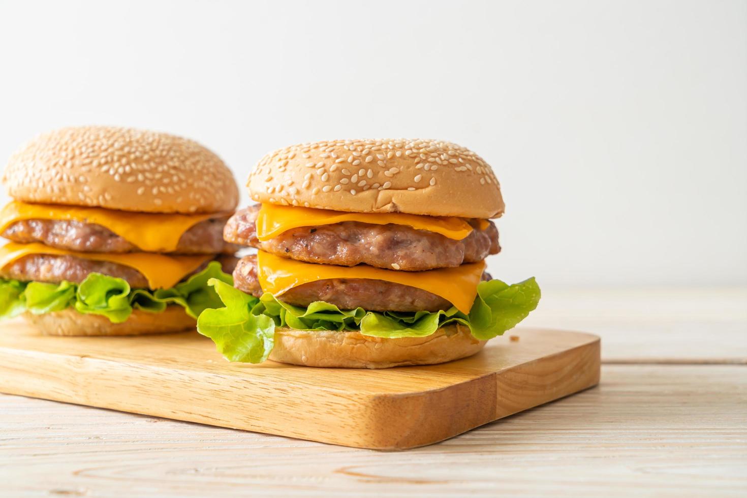 varkenshamburger of varkensburger met kaas op een houten bord foto