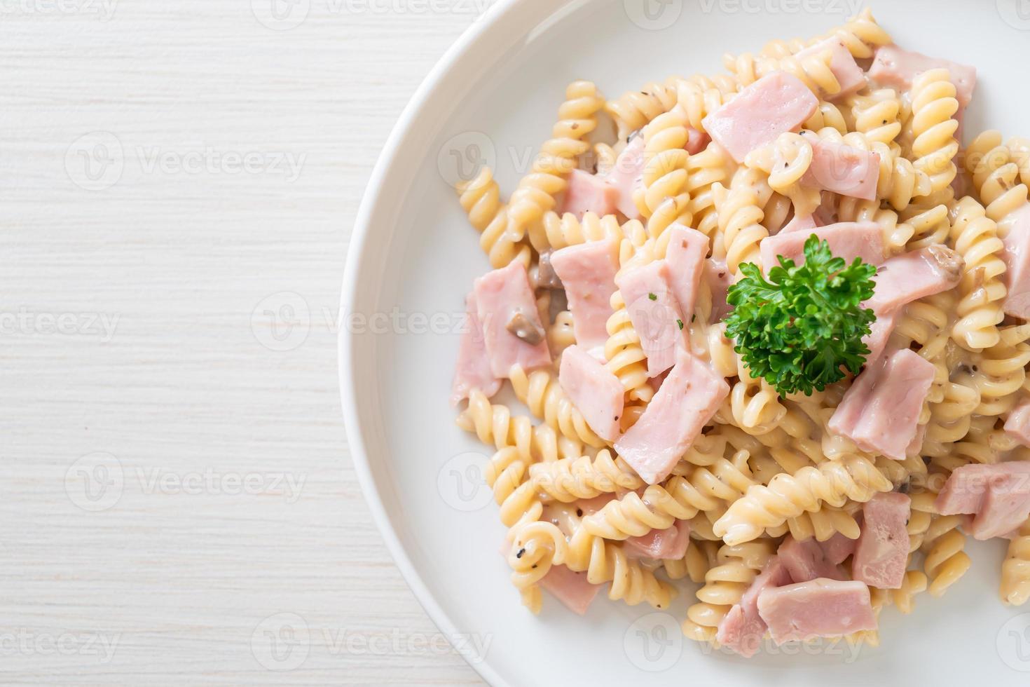 spirali of spirali pasta champignonroomsaus met ham - italiaans eten foto