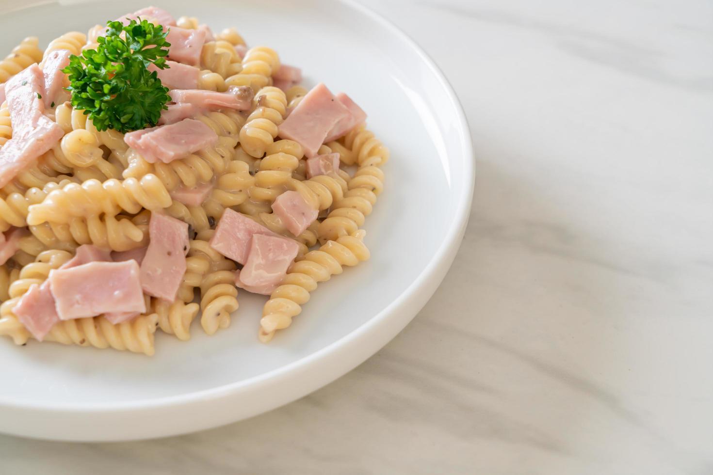 spirali of spirali pasta champignonroomsaus met ham - italiaans eten foto