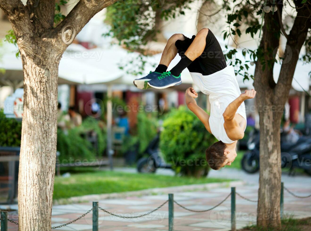 jonge sportman doet front flip in de straat foto