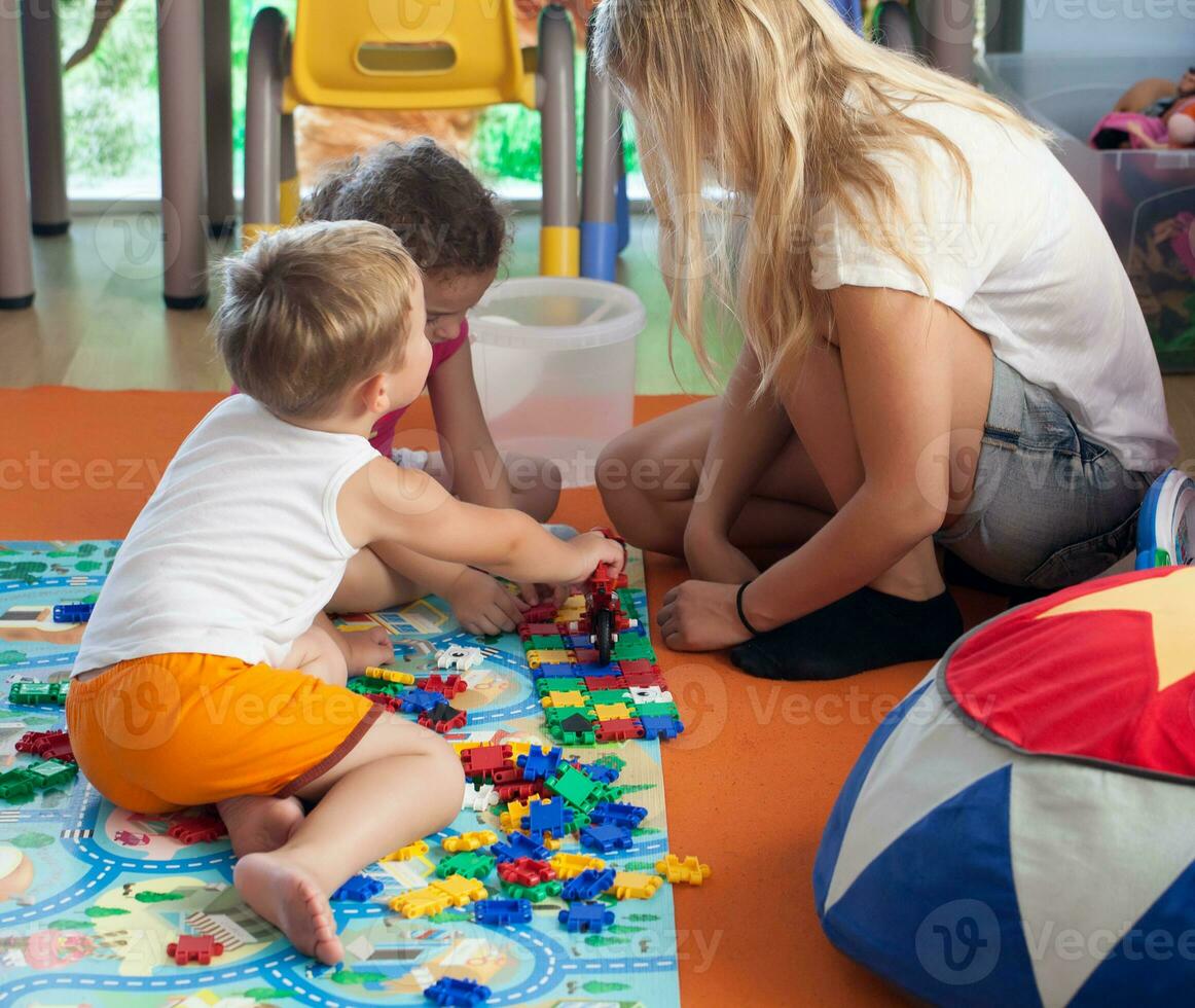 aan het doen puzzel met tutor in kinderkamer foto