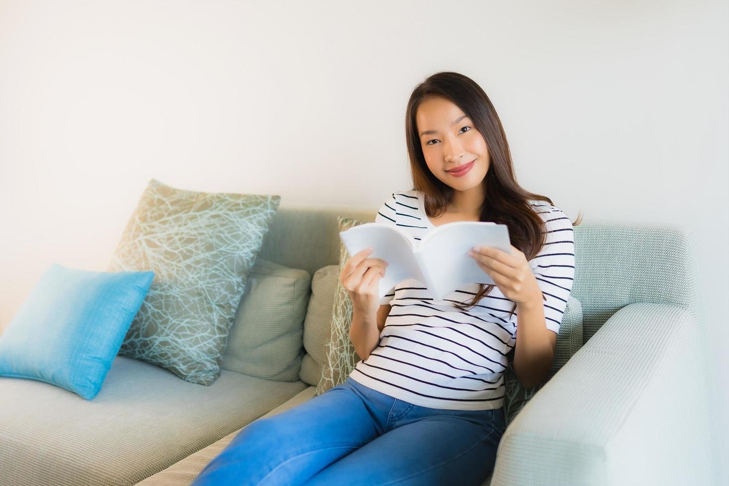 portret mooie jonge aziatische vrouwen die boek met koffiekop lezen foto