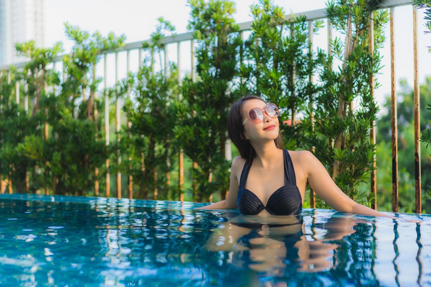 portret mooie jonge aziatische vrouwen gelukkig glimlach ontspannen buitenzwembad in resort foto