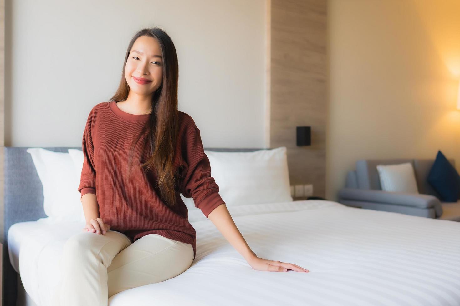 portret mooie jonge aziatische vrouwen gelukkige glimlach ontspannen op bed foto