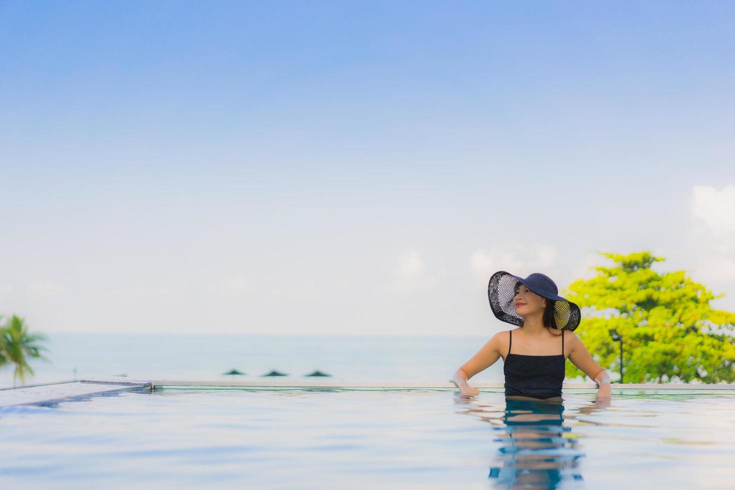 portret mooie jonge aziatische vrouwen gelukkig glimlach ontspannen buitenzwembad in hotel foto