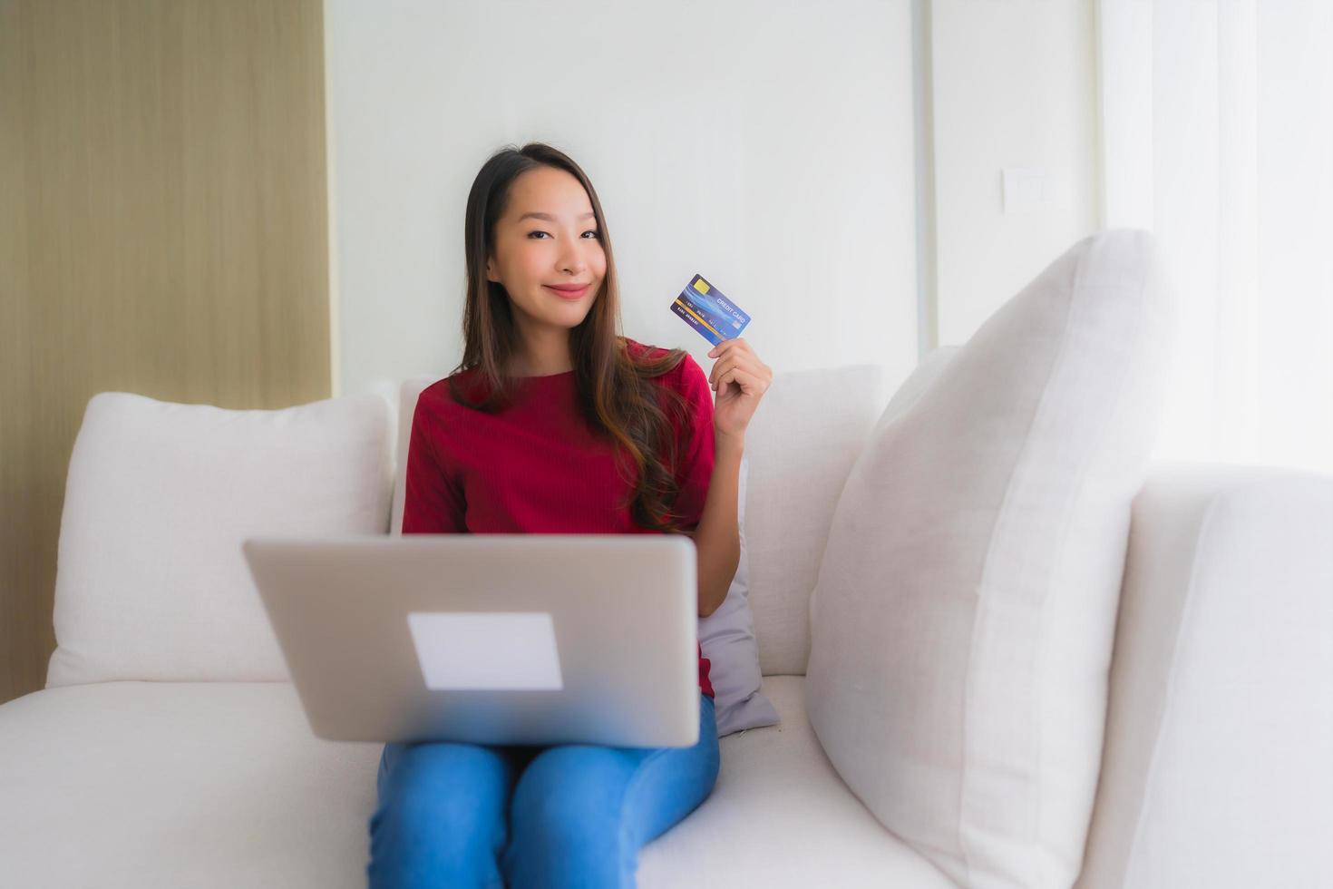 portret mooie jonge aziatische vrouwen die computerlaptop met mobiele telefoon en creditcard gebruiken foto