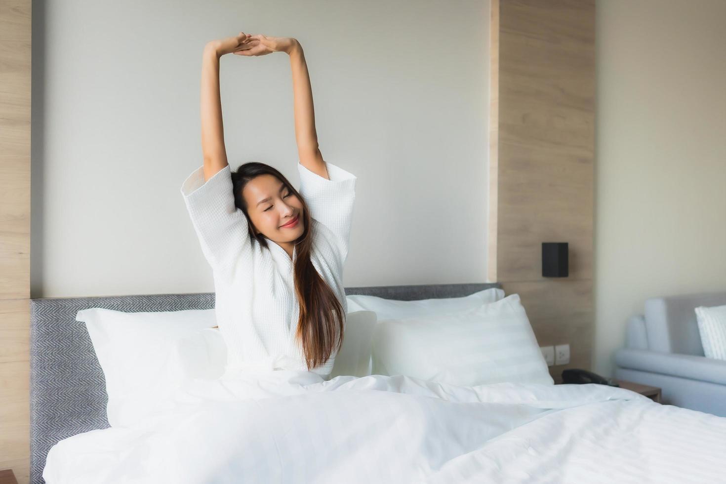 portret mooie jonge aziatische vrouwen gelukkige glimlach ontspannen op bed foto