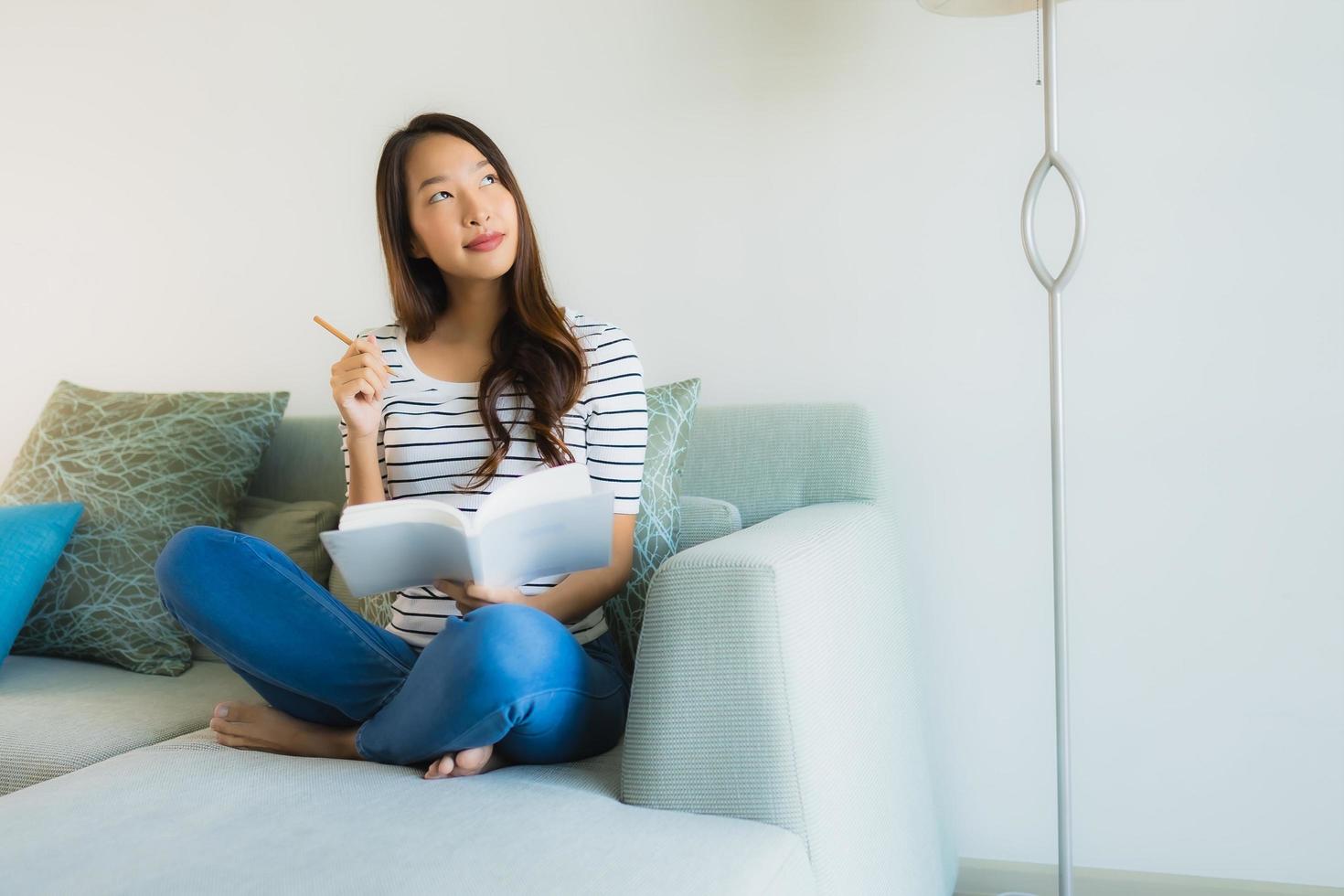 portret mooie jonge aziatische vrouwen die boek met koffiekop lezen foto