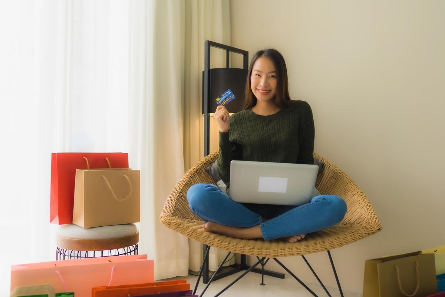 portret mooie jonge aziatische vrouwen die computerlaptop of slimme en mobiele telefoon met creditcard gebruiken voor online winkelen foto