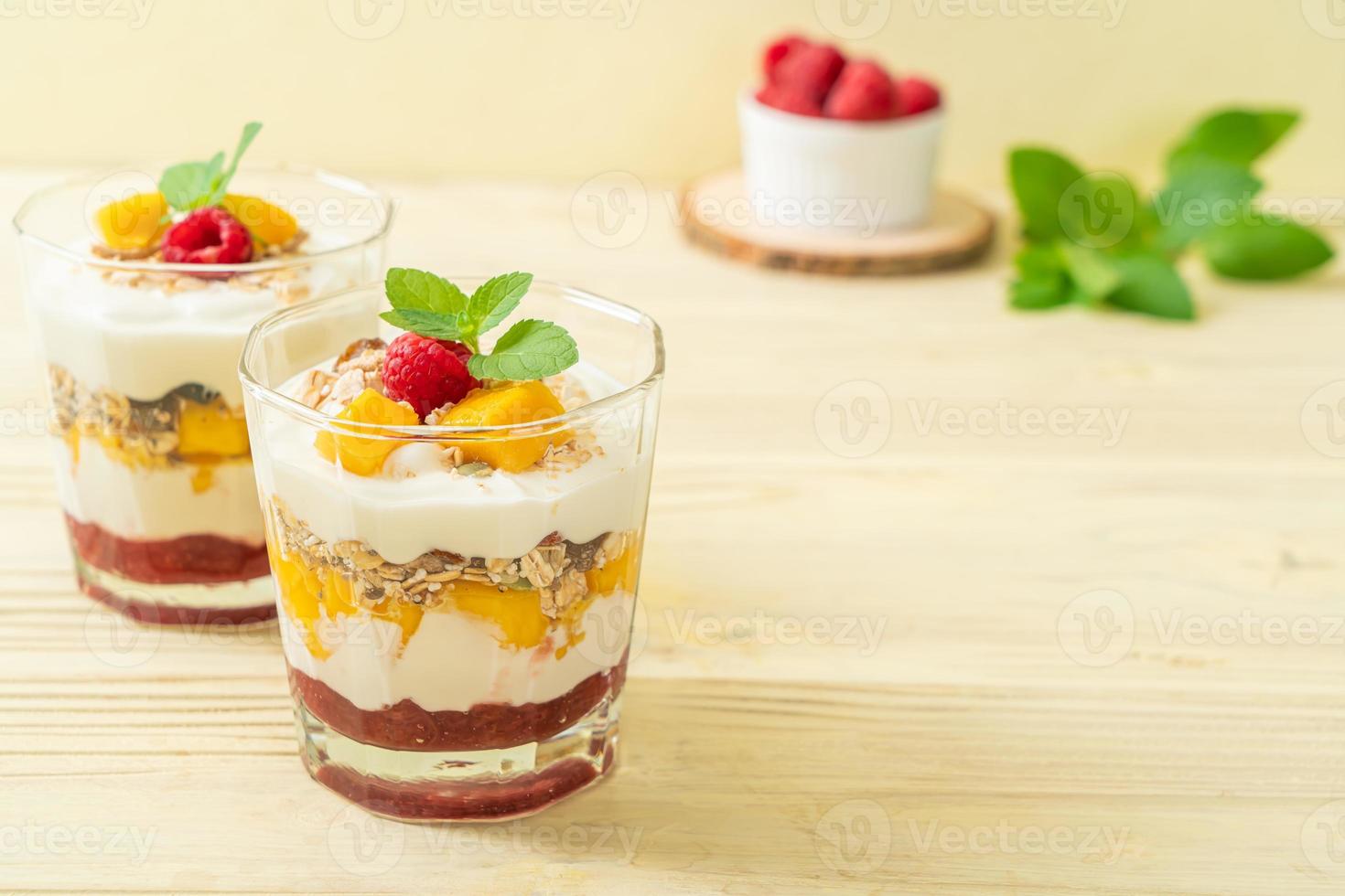 zelfgemaakte verse mango en verse framboos met yoghurt en granola - healthy food style foto