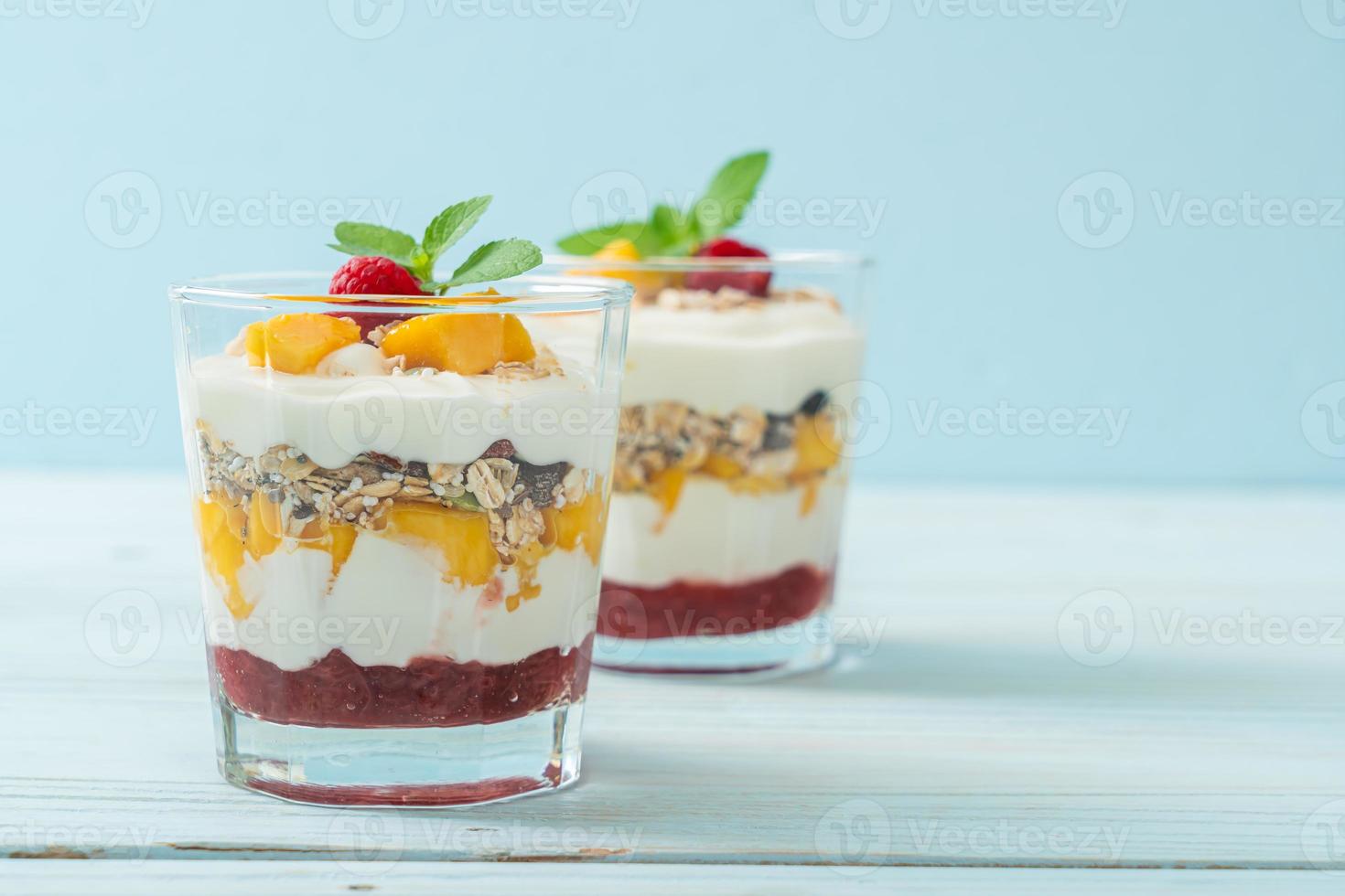 zelfgemaakte verse mango en verse framboos met yoghurt en granola - healthy food style foto