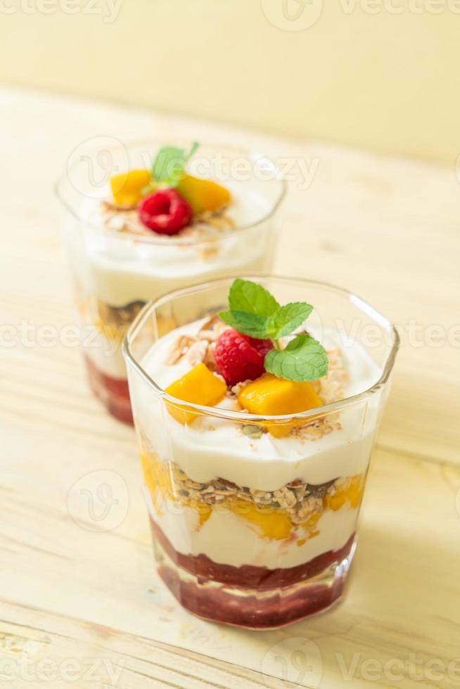 zelfgemaakte verse mango en verse framboos met yoghurt en granola - healthy food style foto