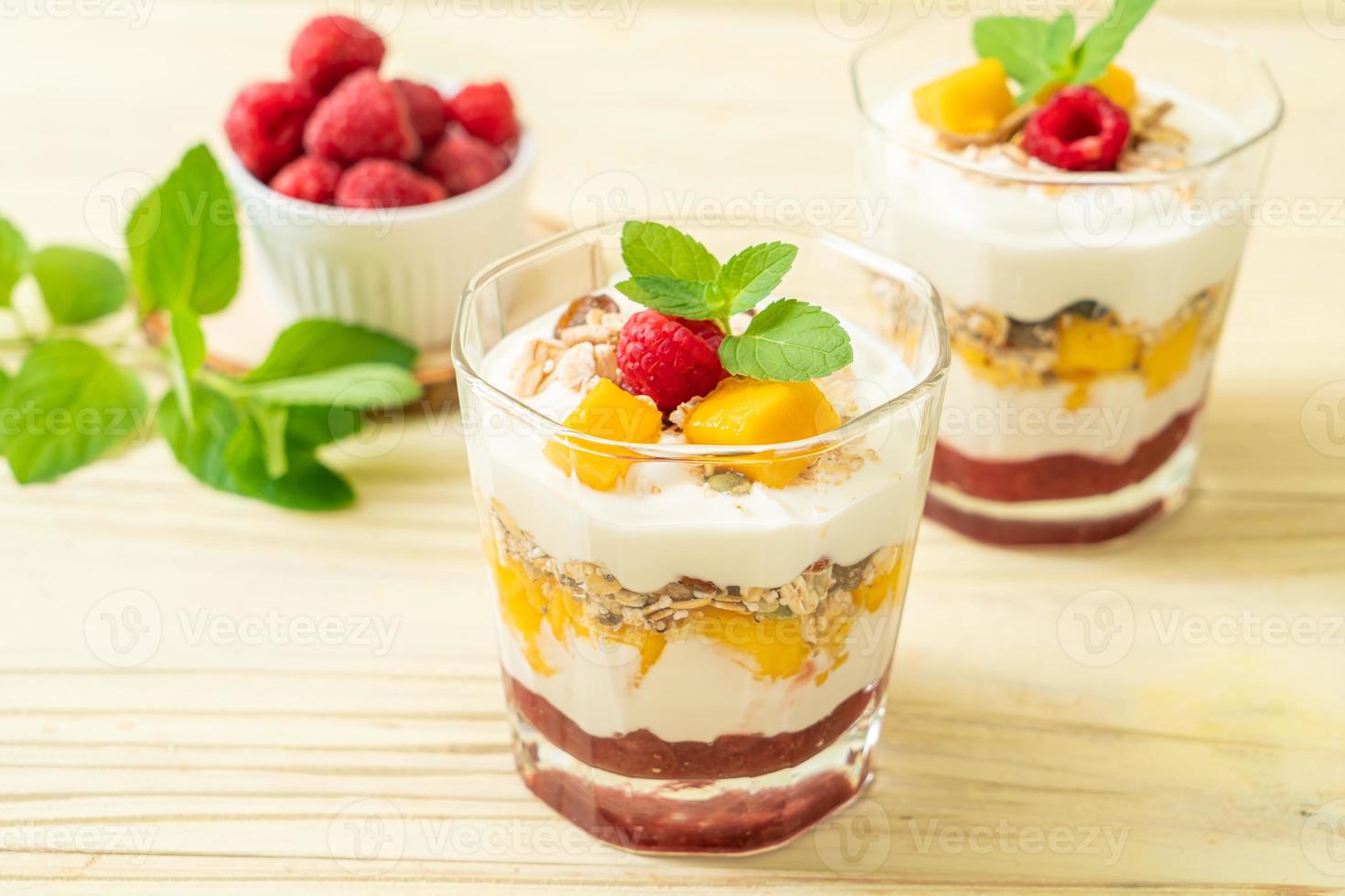 zelfgemaakte verse mango en verse framboos met yoghurt en granola - healthy food style foto