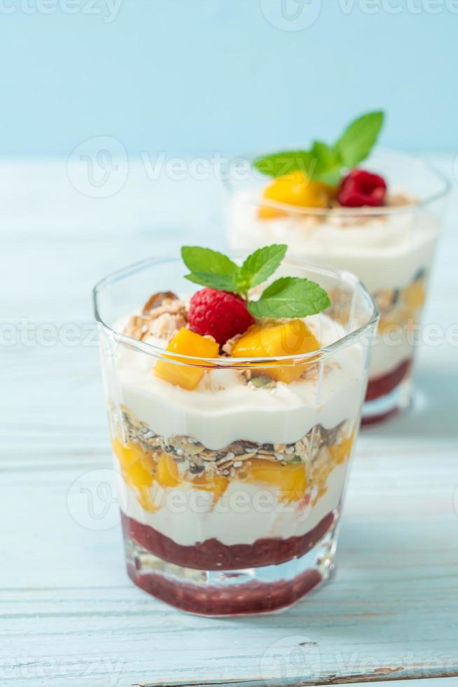 zelfgemaakte verse mango en verse framboos met yoghurt en granola - healthy food style foto