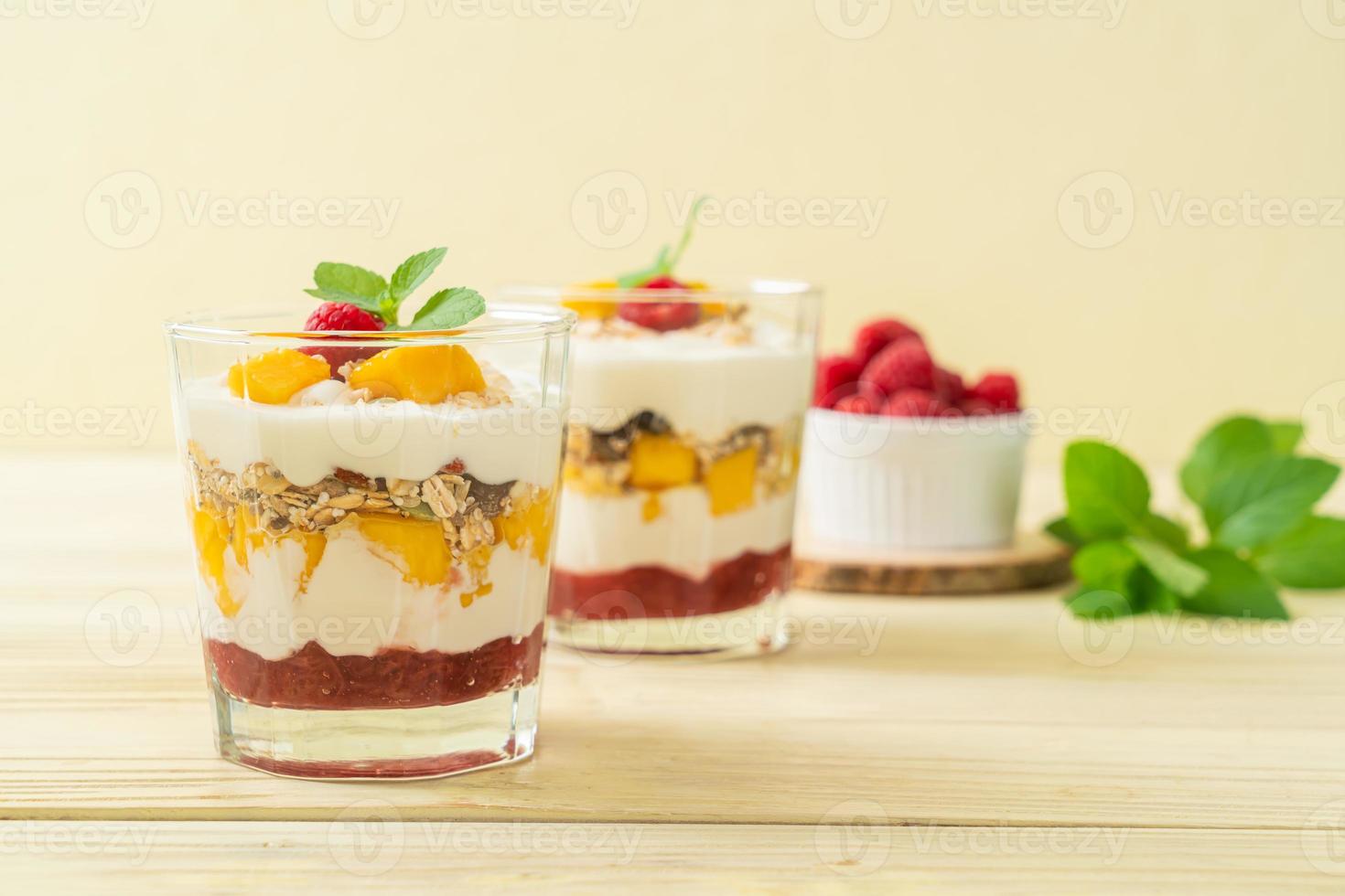 zelfgemaakte verse mango en verse framboos met yoghurt en granola - healthy food style foto